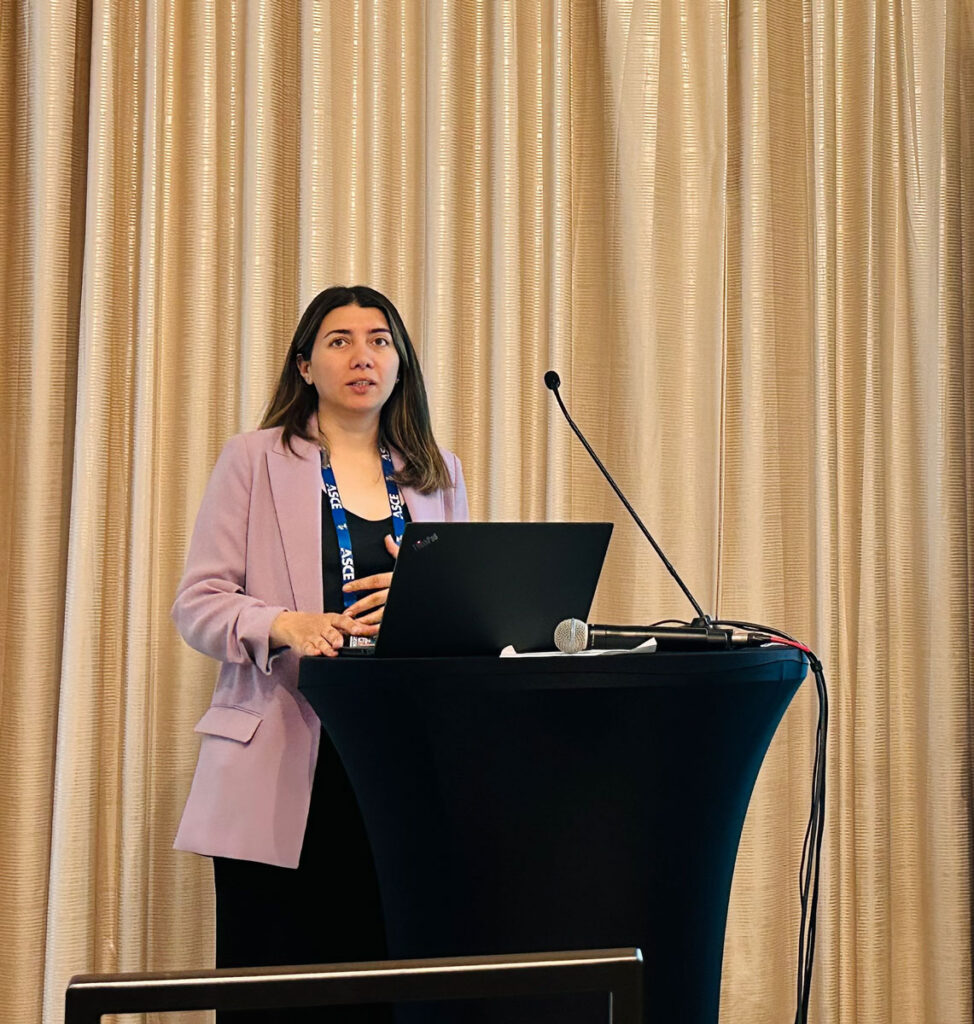 Fariba giving a presentation at a black podium.