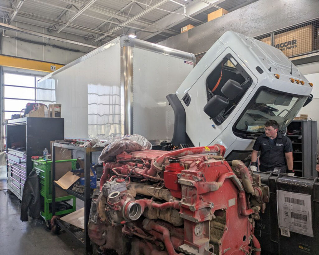 ASPIRE and Kenworth Sales' very first electric Class 6 box truck, with a mechanic who is training how to fix electric trucks, using the ASPIRE truck as a model.