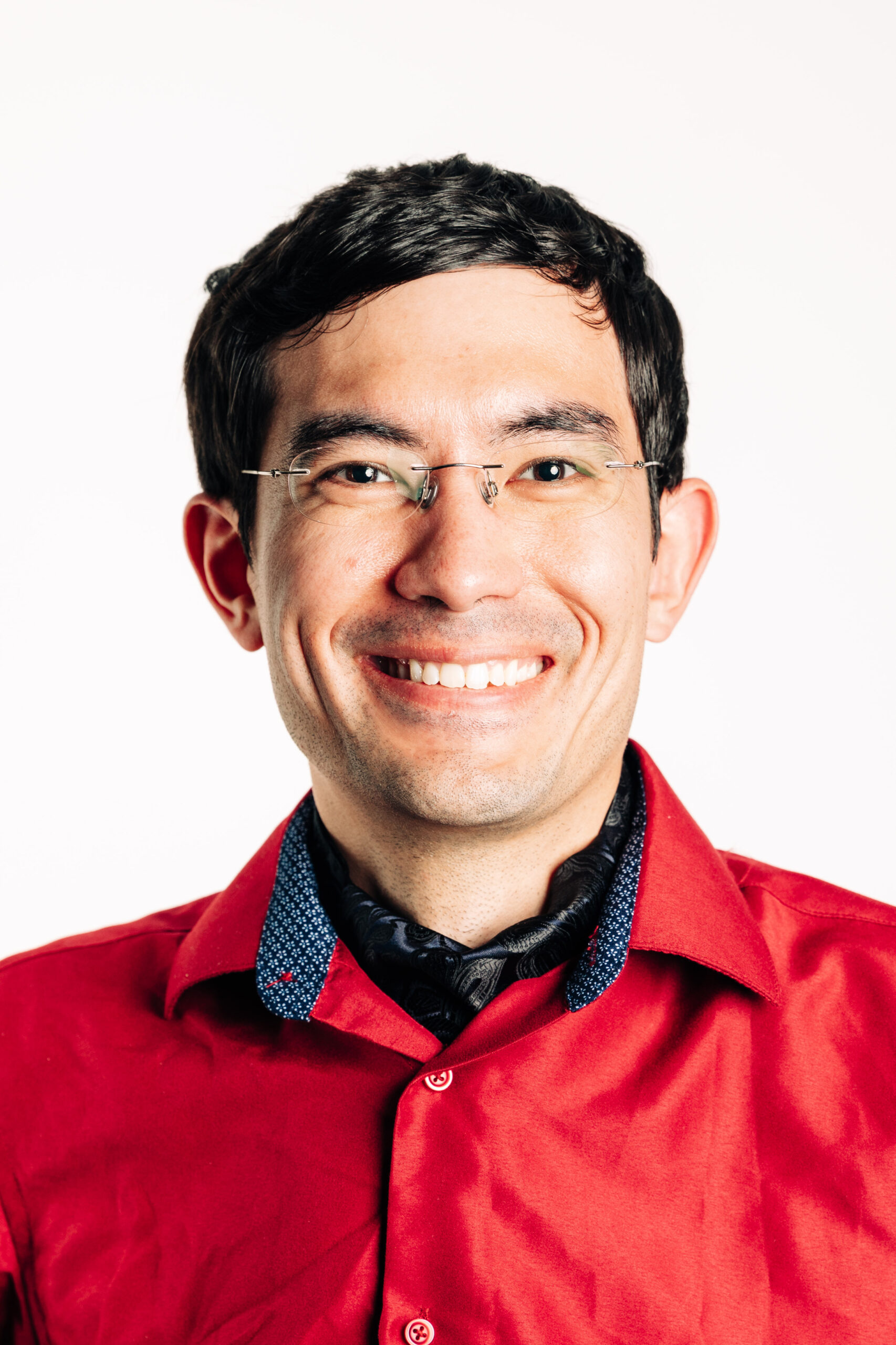 Mario Harper smiling in front of a white background.