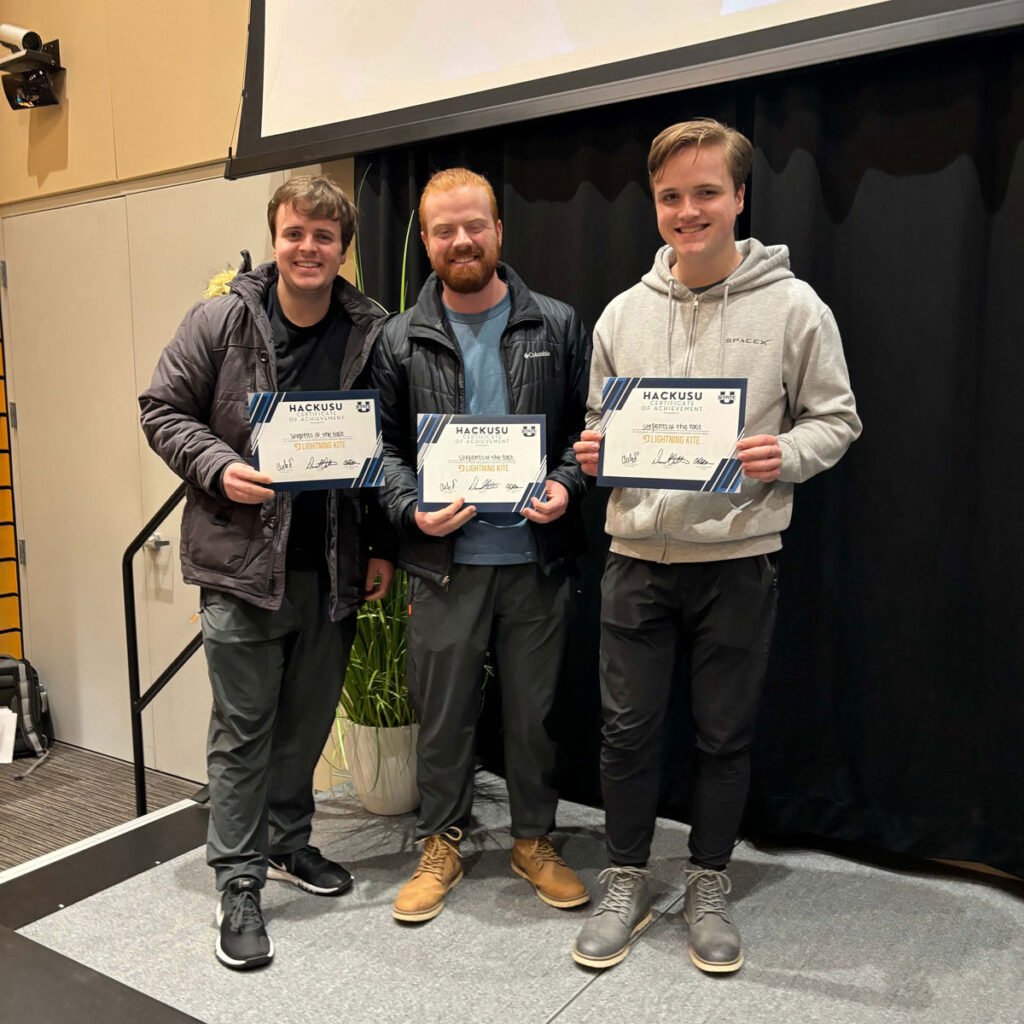 Three USU ASPIRE students receiving certificates for winning in their category at HackUSU.