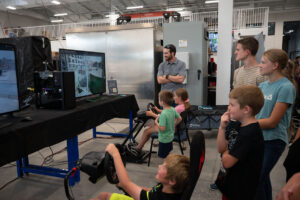 Children at the Open House explore the EV in-motion charging driving simulations.