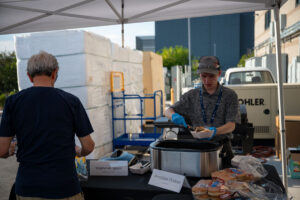 ASPIRE student serves food to guest at the ASPIRE Open House.