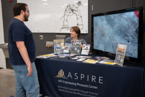 ASPIRE student explains the Utah Electrification Initiative to an Open House guest.