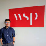 Abdullah Al Mehadi smiling in front of the WSP sign, where he interned.