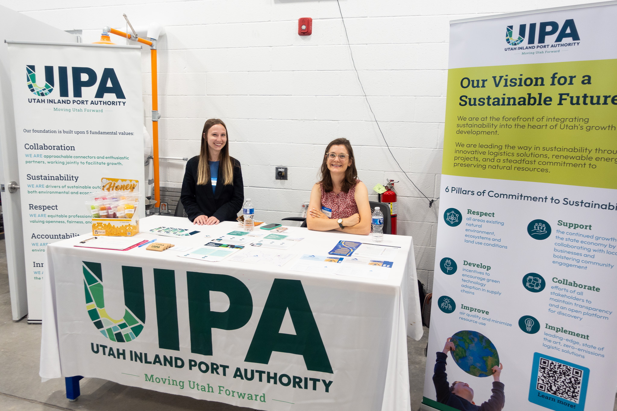 Two representatives from UIPA smile at the camera from behind their table as they prepare to greet and share with guests at the ASPIRE EVR Open House on July 17.