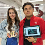 Students hold up their model EV and presentation as a part of the ASPIRE curriculum.