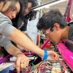 Students work on wiring for an electric vehicle from Switch Vehicles' Switch Labs program.