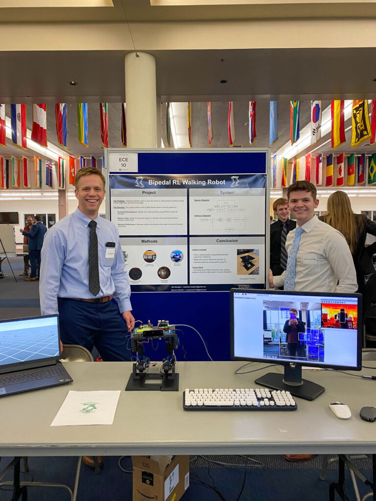 Zac Maughan with his partner showing off their poster and robot at the USU Senior Design Night.