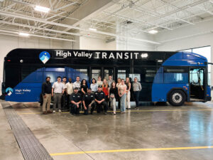 ASPIRE Student Cohort trip posing for a group photo at High Valley Transit in front of an electric bus.
